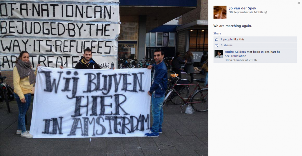 Fig. 2. White marching banner with the text “Wij blijven hier in Amsterdam” (trans. We will stay here in Amsterdam). Posted by Jo van der Spek on Facebook, 30 Sept, 2013, with the comment “We are marching again.” (Screen Shot taken on 4 October 2013, 16:18:13 from https://www.facebook.com/photo.php?fbid=660125667344666)